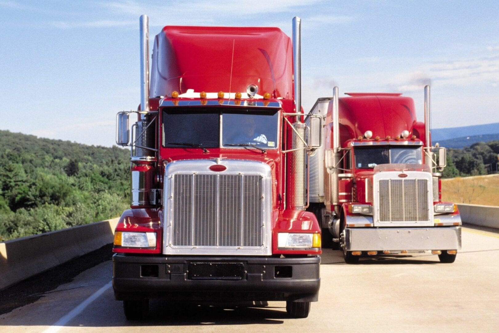 2 red peterbilt trucks