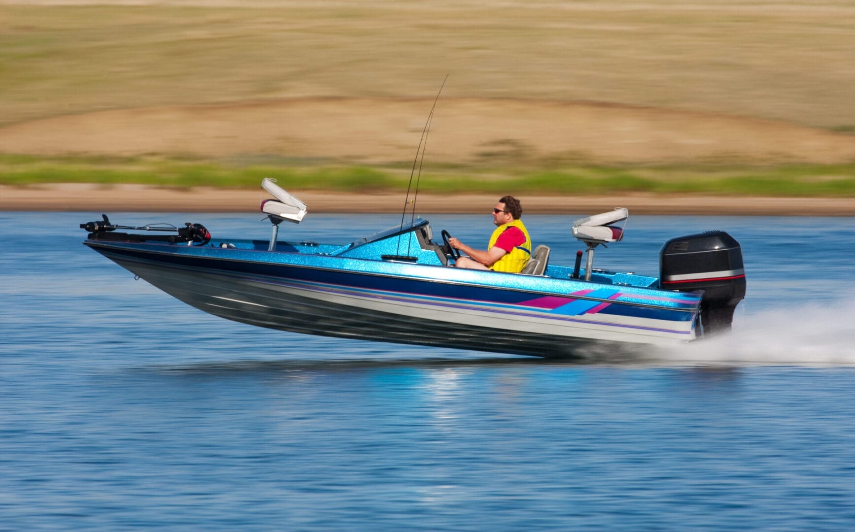 Man driving a fast boat with panned (motion blur) background