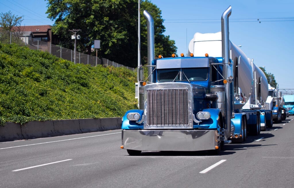Transport diesel trucks transporting materials on a highway.