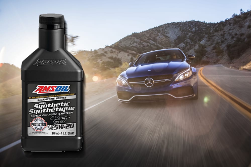 AMSOIL 5W-20 Synthetic motor oil in front of a Mercedes-Benz driving on a road