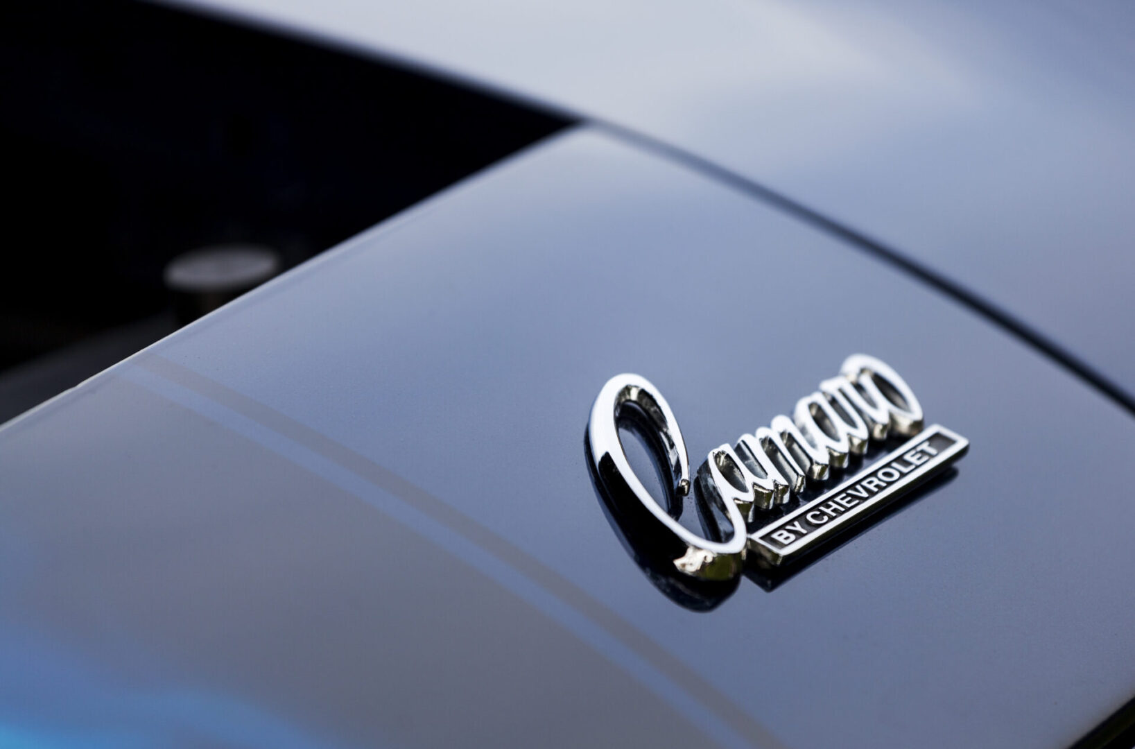 Bedford, Nova Scotia, Canada - June 28, 2011: Chevrolet Camaro emblem (Camaro by Chevrolet) on hood of vehicle.  Ahead of logo the engine bay is open and visible.  The Camaro was first introduced in 1966 and is currently in its fifth generation (as of 2011).