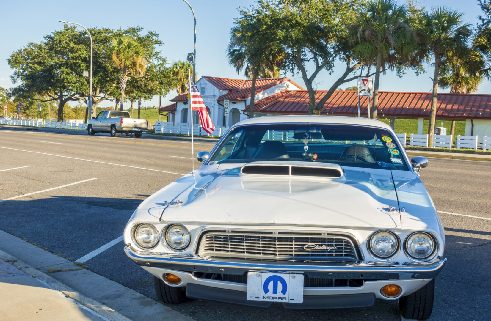New Orleans, USA - Nov 26, 2017: A white Dodge Challenger car stationed in a public parking space. It sports a small American flag on its antenna. Near Lake Pontchartrain.